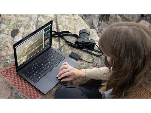 Femme photographe faisant le tri de ces photos professionnelles stockées sur disque dur via son PC portable