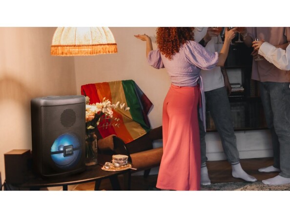 Installation de l'enceinte sans fil bluetooth PBX-150 New One sur une table basse pendant une fête entre ami organisée dans un salon