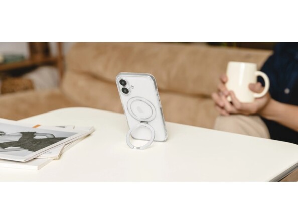 Mise en situation du positionnement vertical d'un iPhone sur support MagSafe 2 en 1 sur une table basse de salon devant une personne tenant une tasse des deux mains