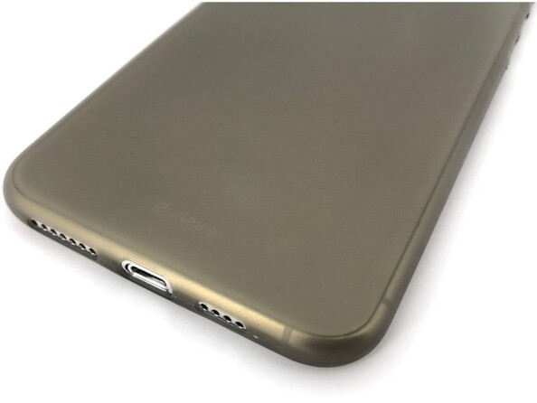 Vue arrière rapprochée au niveau des sorties audio et du port de chargement Lightning libres d'un iPhone posé sur son écran avec coque de protection noir usagée