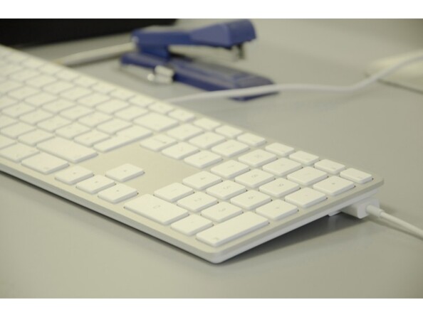 Vue de biais côté droit du clavier AZERTY KB-1243 LMP branché à un PC par câble USB à côté d'une agrafeuse bleue