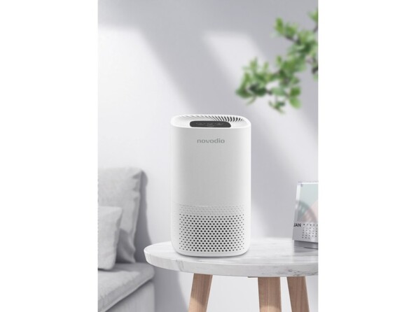 Assainisseur d'air 230 V coloris blanc format tour posé sur une table basse dans un salon clair