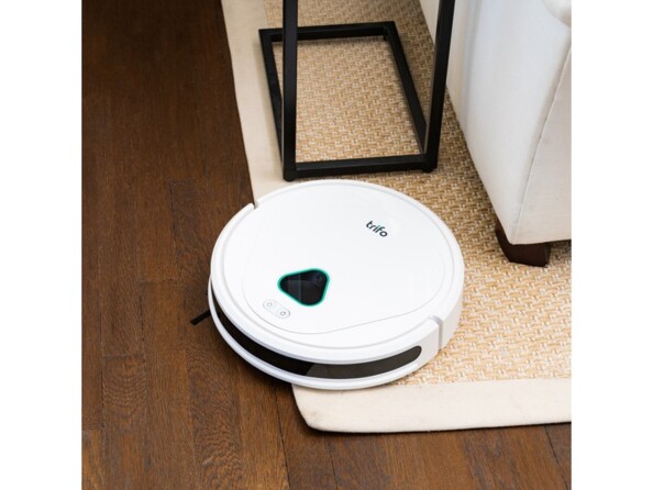 Nettoyage d'un sol et d'un tapis à côté d'une table basse et d'un canapé