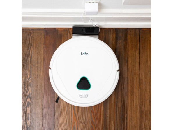 Chargement en cours du robot aspirateur rond Trifo Max coloris blanc sur une station de charge branchée sur secteur