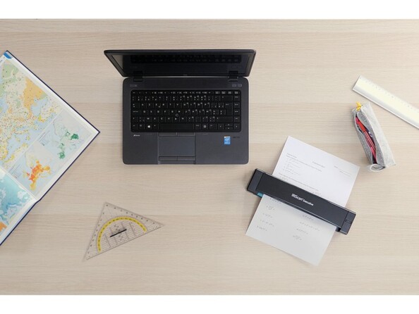 Mise en situation de la numérisation d'une feuille de papier A4 avec le scanner sans fil iris executive 4 en connexion avec un PC Windows sur un bureau en bois clair