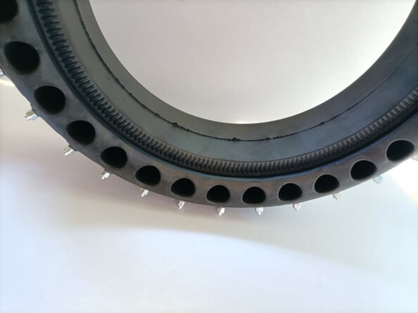 Zoom sur la structure alvéolée du pneu en caoutchouc avec crampons amovibles en tungstène