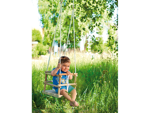 Un petit garçon profite de son siège de balançoire en bois Playtastic en toute sécurité.