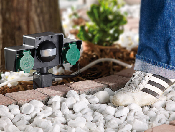 Installation de la double prise Revolt avec capteur d'obsucrité dans un jardin.