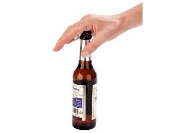 Main utilisant un décapsuleur métallique pour ouvrir une bouteille brune avec étiquette, fond blanc
