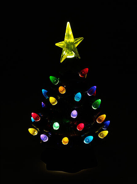 Sapin céramique illuminé dont les ampoules irradient sur fond noir