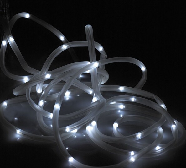 Guirlande lumineuse LED en tube flexible transparent enchevêtrée sur surface sombre