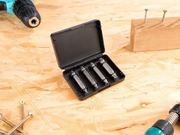 4 extracteurs dans leur boîtier de rangement posé sur un plan de travail d'atelier à côté d'autres outils