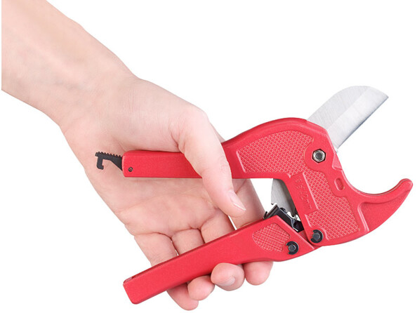 Coupe-tube en plastique AGT tenu dans une main.