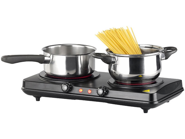 Deux casseroles grises avec spaghetti cuisant à l'intérieur posées sur chacune des deux plaques de cuisson