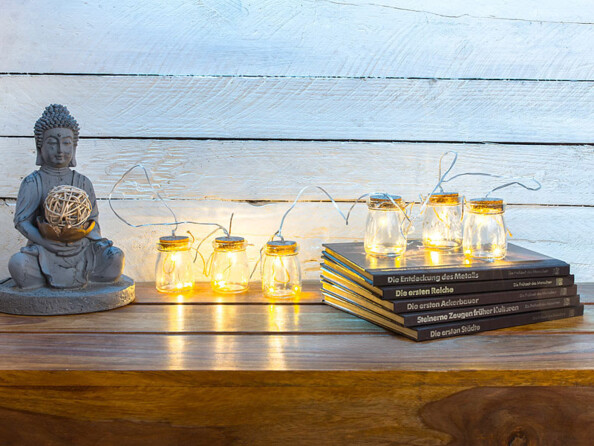 6 bocaux lumineux décoratifs posés sur un meuble