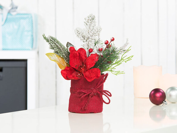 Composition florale de Noël avec fleurs, branches, baies et neige artificielle