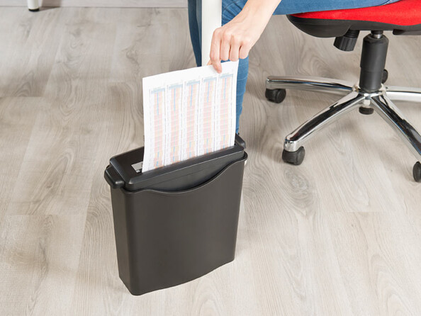 Feuille A4 important en cours de déchiquetage par un employé de bureau au-dessus du réservoir 8 L