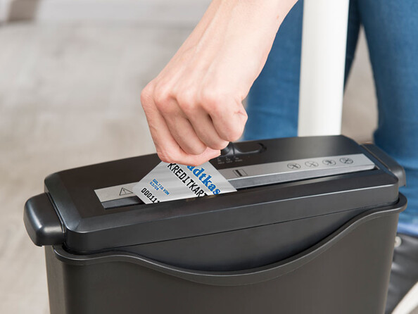 Personne détruisant une carte de crédit par le biais du destructeur de documents