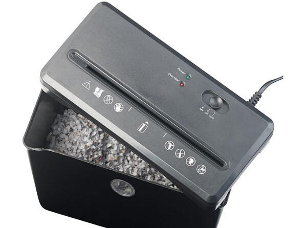 Destructeur de documents ouvert vue du dessus avec papier tranchés en fines bandes dans le bac collecteur