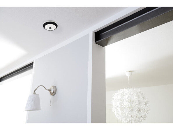 Caméra de surveillance IPC-525.wide fixée au plafond dans un couloir.