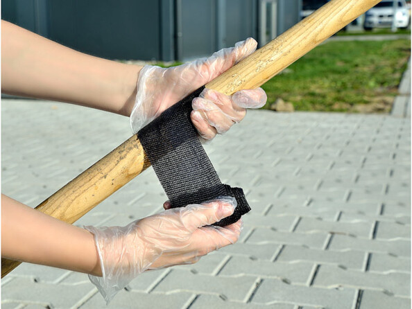 Réparation d'un bâton à l'aide d'un rouleau adhésif en tissu noir