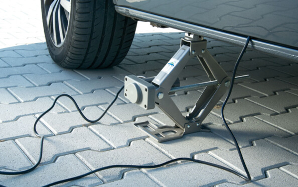 Cric électrique placé à l'endroit prévu sur le châssis du véhicule.