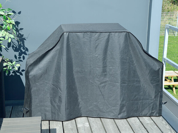 Barbecue sur une terasse protégé par une housse étanche pour lutter contre la pluie, la neige ou le soleil
