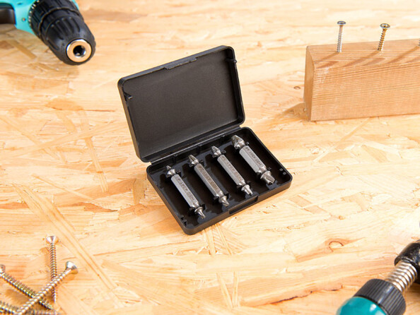 4 extracteurs dans leur boîtier de rangement posé sur un plan de travail d'atelier à côté d'autres outils