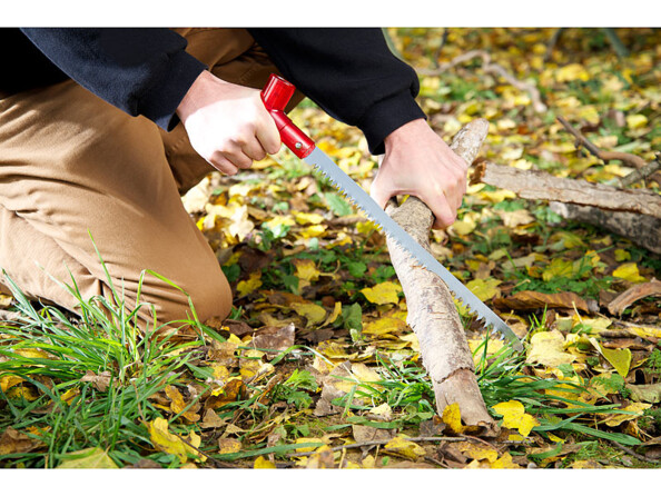 Personne coupant un morceau de bois dans la forêt avec la lame coupante de la pelle à neige