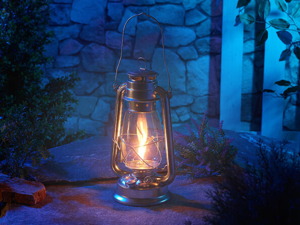 Mise en situation de la lampe-tempête Lunartec allumée, placée sur un chemin en extérieur dans l'obscurité