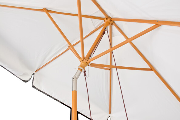 Zoom sur le mécanisme à basculement du parasol de jardin beige et son articulation rotative