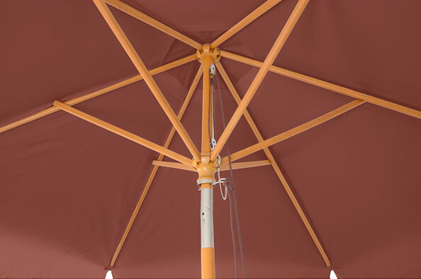 Gros plan sur la structure en bois de hêtre du parasol avec corde pour ouverture et fermeture