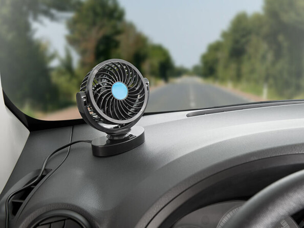 Ventilateur de voiture posé sur le tableau de bord, branché sur allume-cigare pendant la conduite