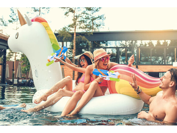 Pool party entre amis avec bouée licorne et pistolets à eau