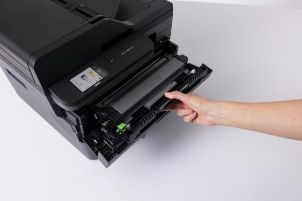 Remplacement de la cartouche de toner noir à la une main dans une imprimante laser Brother coloris noir