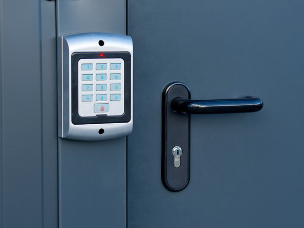 Clavier de système d'alarme factice avec voyant rouge fixé à côté d'une porte d'entrée