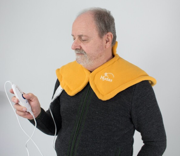 Un homme qui porte le coussin chauffant Hydas sur les épaules.