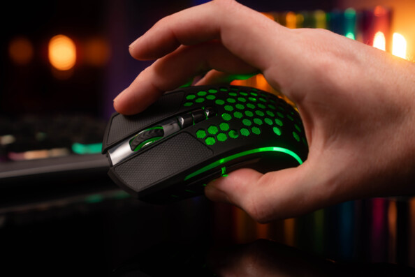 Prise en main de la souris sans fil avec surface de clic en silicone et revêtement alvéolé noirs visible via rétroéclairage ver, molette et 3 boutons sur le dessus de la souris et 2 boutons sur le côté