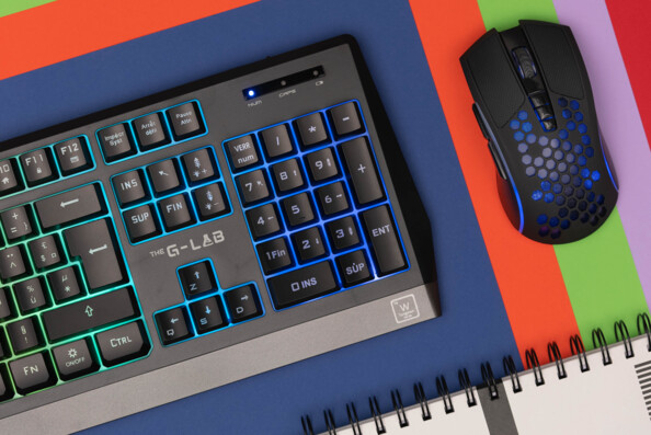 Zoom sur le pavé numérique et les touches du clavier et sur le dessus de la souris sans fil, tous rétroéclairés en bleu, les 7 boutons et la molette de la souris sont apparents avec revêtement en nid d'abeille de la souris