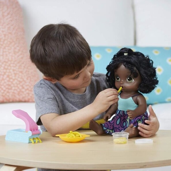 Le petit garçon nourrit sa poupée Baby Alive miam miam les bonnes pâtes.