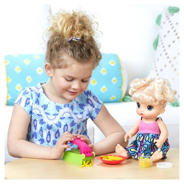 Cette petite fille préparer les faux spaghettis à sa poupée Baby Alive Miam miam les bonnes pâtes.