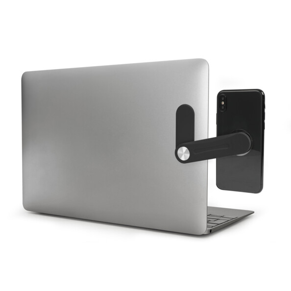 Ordinateur gris ouvert avec support téléphone collé et smartphone aimanté au support noir situé sur le côté de l'ordinateur