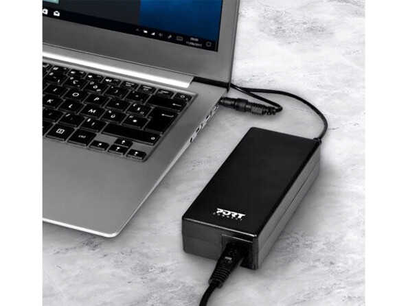 Bloc d'alimentation secteur rectangulaire coloris noir avec logo blanc Port Connect branché à un ordinateur portable Acer ou Toshiba noir et gris par le biais de son câble d'alimentation en 2 parties