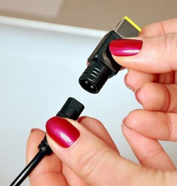 Personne illustrant le fait que les embouts sont amovibles en tenant dans sa main droite un embout et dans sa main gauche le câble de raccordement du chargeur