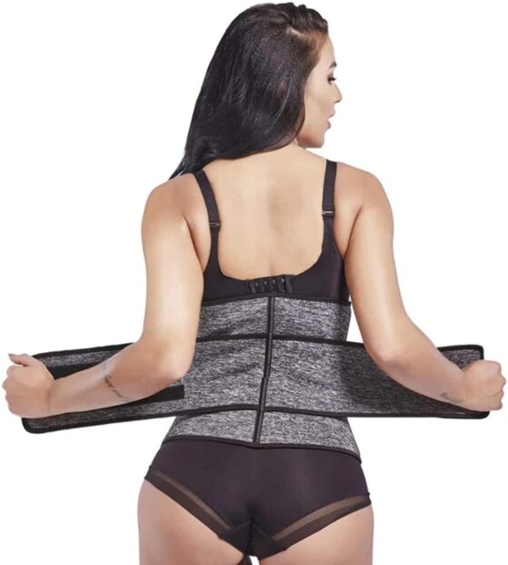 Vue de dos d'une femme positionnant la ceinture de sudation et harnais correcteur de posture au niveau des lombaires sur un body fitness