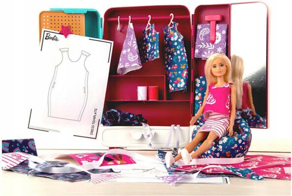 Dressing ouvert avec poupée Barbie assise, cintres, ruban adhésif, fils, boutons, sequins, tissus, stickers et patrons de couture accrochés à la porte intérieur de la garde-robe