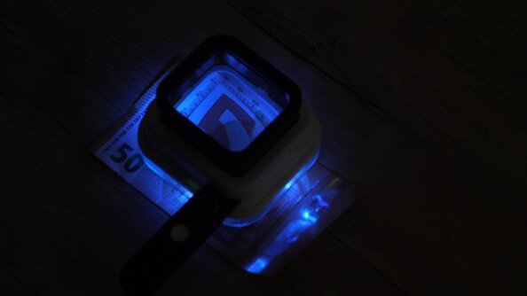 Observation d'un billet de 50 euros avec la lumière des 4 LED UV de la loupe grossissante carrée Genius Ideas