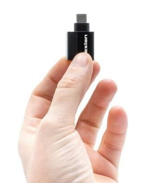 Main d'une personne tenant entre ses doigts le mini adaptateur Dexlan réf. 310700 coloris noir avec fiche USB-C 3.1 Gen 1 et port RJ45