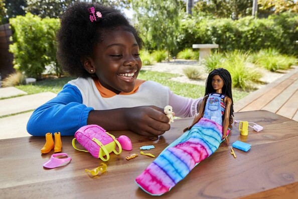 Fille qui s'amuse avec Barbie au camping