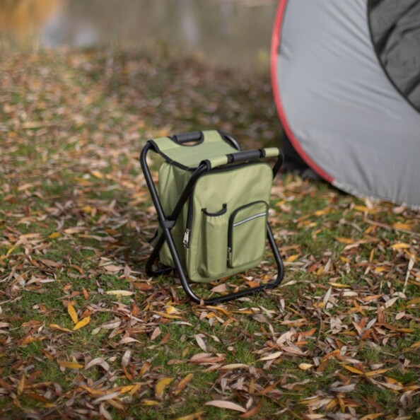 Siège de camping et sac à dos de transport déplié et posé dans la nature à côté d'une tente montée